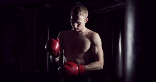 Young Male Boxer Preparing for Workout in Gym
