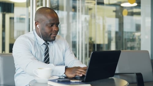 Young Adult Man Working on Laptop in Office