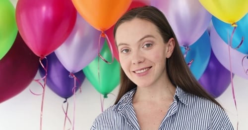 Smiling Woman with Colorful Balloons Backdrop