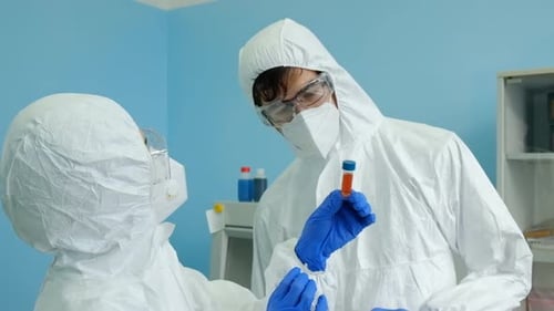 Científicos, virólogos y biólogos, un hombre y una mujer en el laboratorio discutiendo el acabado