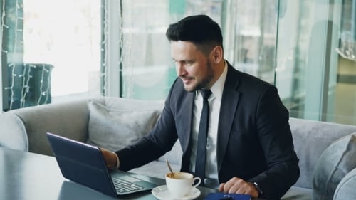 Man Waving During Video Call in Office