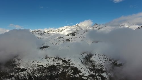 Snow Capped Mountains and Drifting Clouds Aerial View