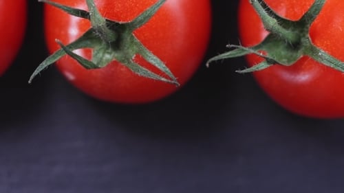 Reife Kirschtomaten auf schwarzem Hintergrund