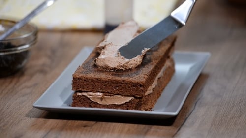 Female Hands Smears Cake with Chocolate Cream