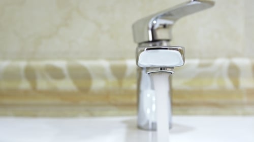 Modern Faucet Dispensing Water in Bathroom Sink