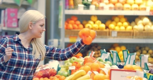 Woman Choosing Orange at Fruit Vegetable Supermarket