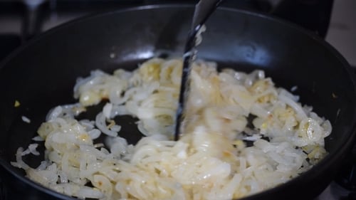 Cebolla frita en aceite en una sartén