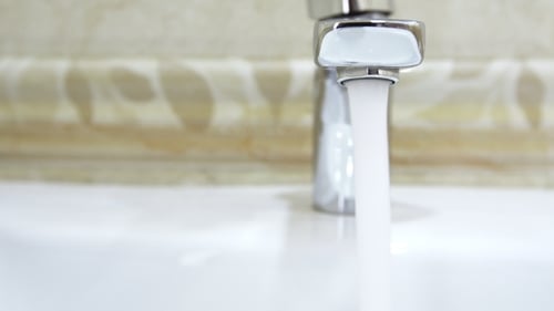 Water Running from Faucet into Sink Close Up