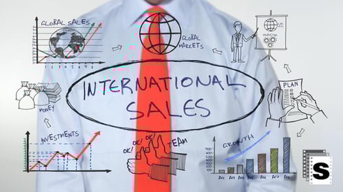 Man Writes International Sales Concept on Clear Surface