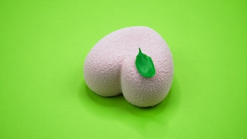 Bright and Colorful Cake Heart on a Green Background. Rotating Top View.