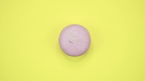 Pink Macaron with Sprinkles on Yellow Background