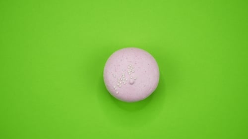 A Colorful Macaroons Are Rotating on a Green Background