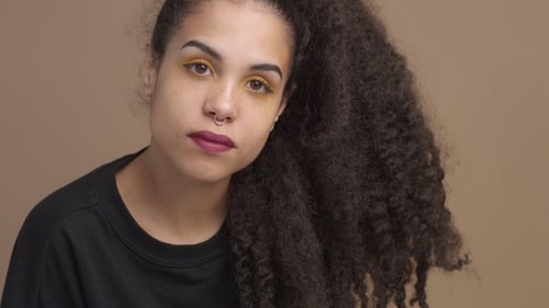 Stylish Woman with Dark Curly Hair Posing