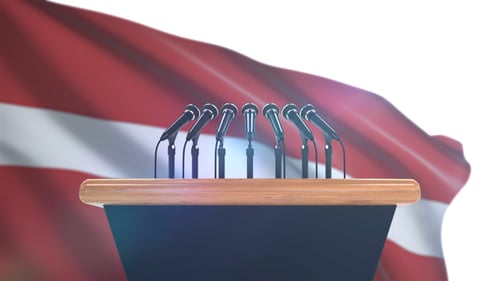Animated Podium with Many Microphones and Waving Flag Background