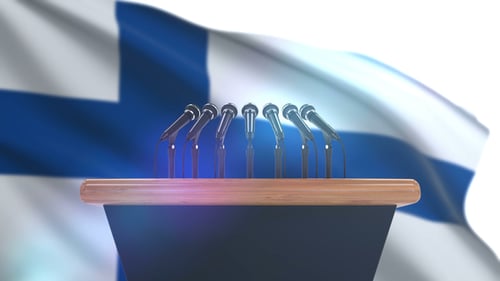 Press Conference Podium with Microphones and Waving Finnish Flag