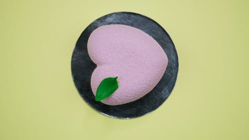 Heart-Shaped Pink Cake with Green Leaf Decoration