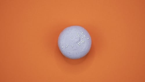 Lavender Macaron with Sprinkles on Orange Background