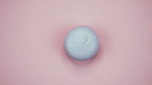 Isolated Purple Macaron Sprinkled on a Pink Surface