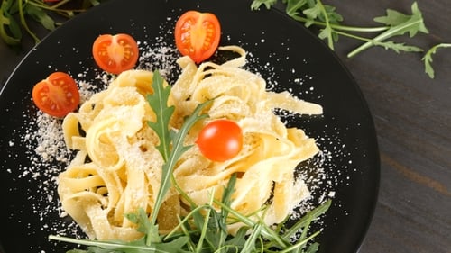 Pasta with Tomatoes and Arugula on Dark Table