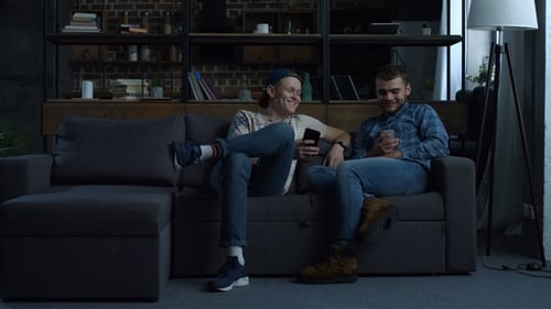 Young Adults Relaxing on a Sofa with Smart Phones