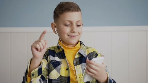 Boy Listens to Music on Smart Phone