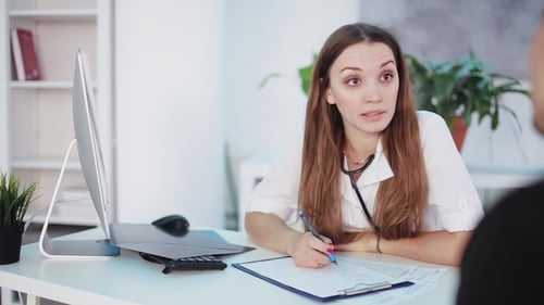 Female Doctor Consults with Patient in Office
