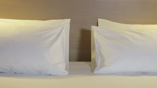 Clean White Pillows on Made Bed in Hotel Room