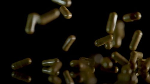 Pill Capsules Falling on the Mirror Table
