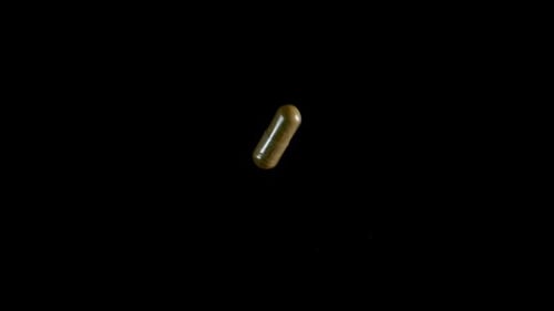 Pill Capsule Falling on the Mirror Table