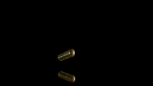 Pill Capsule Falling on the Mirror Table