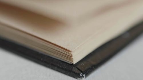 A Man Flips Through Pages in a Book