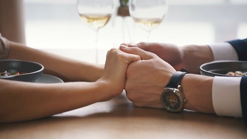 Young Couple Holding Hands in Cafe