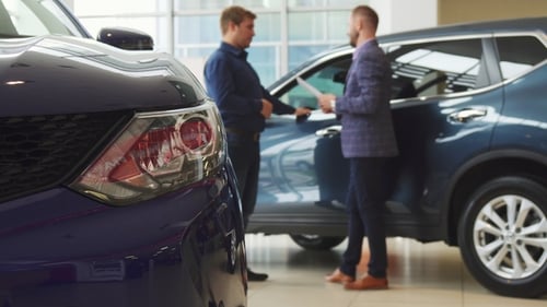 Men Shaking Hands Over Car Purchase in Showroom