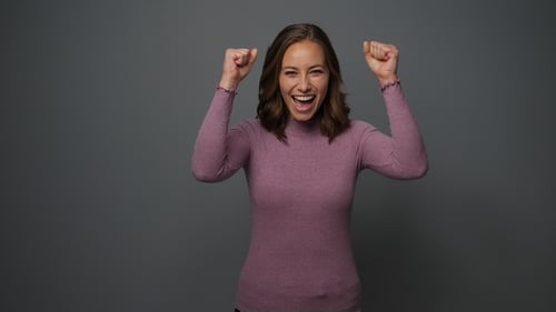 Smiling Woman Celebrates Success in Studio