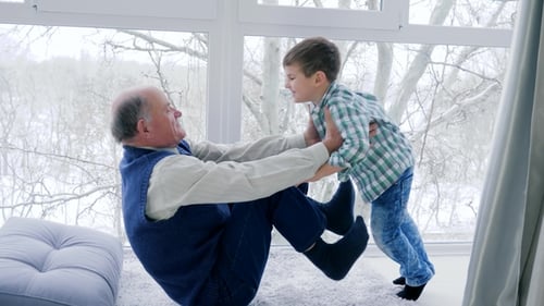 Grandfather Lifts Grandchild High in the Air