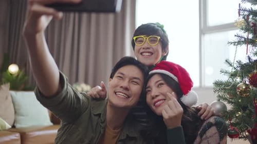 Festive Family Taking Christmas Selfie Together at Home