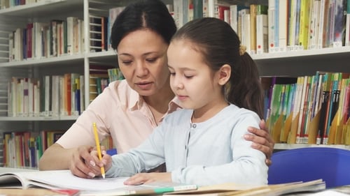 Child Studying with Adult in Library Setting