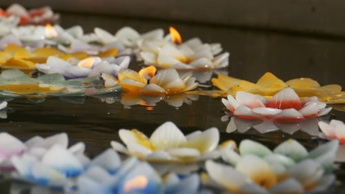 Colorful Candles in Lotus Shape Floating on Water in a Buddhist Temple. Pattaya. Thailand.