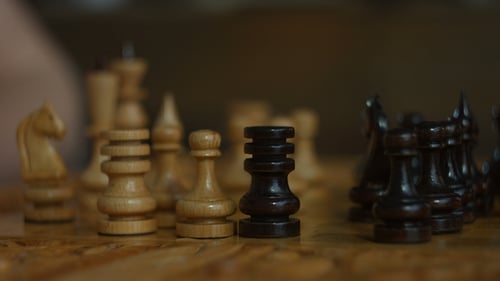 Hand Moves Chess Pieces on Board