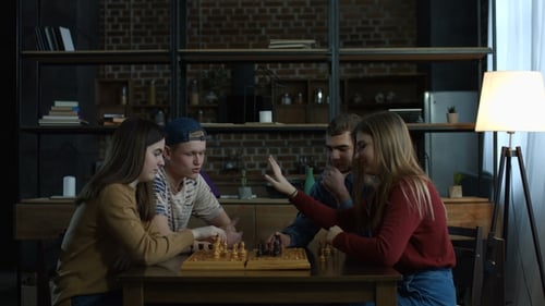 Junge Männer bringen freudigen Freundinnen Schachspiel bei