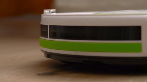 Robotic Vacuum Cleaner Sweeping on Wooden Floor