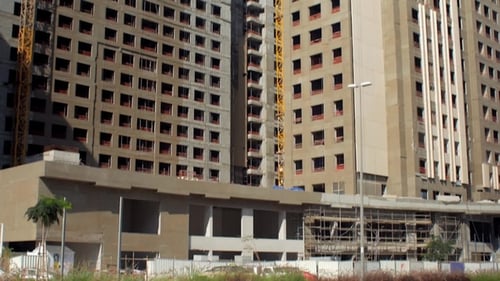 Vertikales Panorama zweier im Bau befindlicher Hochhäuser im Zentrum der modernen Stadt an sonnigen Tagen