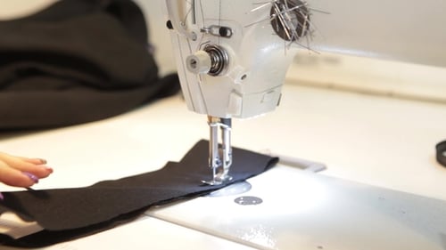 Hands Sewing Black Fabric with Sewing Machine