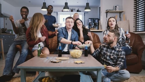 Amigos assistem esportes na TV, torcem e comemoram. Fãs felizes de apoiadores diversos sentam-se no sofá com