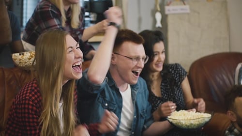 Friends Cheerfully Watch Sports Game Together at Home