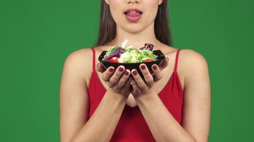 Foto recortada de una hermosa mujer sexy lamiendo los labios sosteniendo un tazón de ensalada
