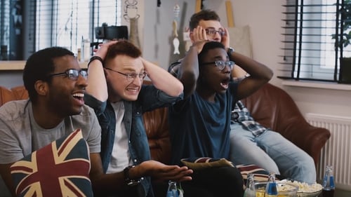 Excited Friends Cheer Together on Couch