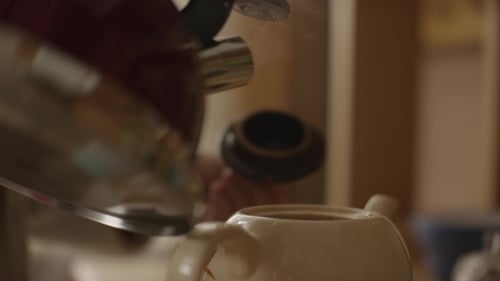 Woman Pours Boiling Water Into the Cup and Brew Tea in a Tea Bag. The Woman Pours Hot Water