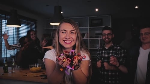 Beautiful European Girl Blowing Out Confetti Happy Excited Lady Blows Glitter on Multi Ethnic Party