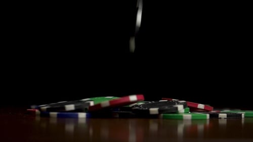 Colorful Casino Chips Falling on Reflective Surface